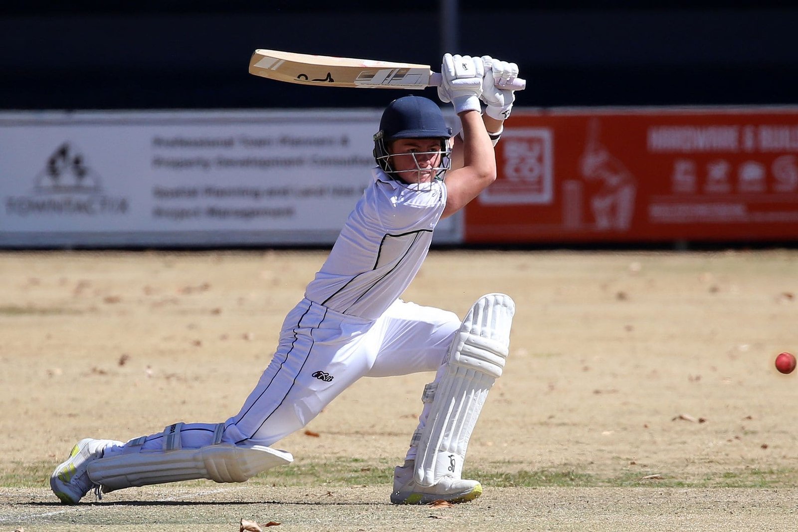 Junior cricketer playing a drive during a match